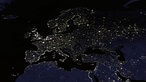 Satellitenaufnahme von Europa bei Nacht. Die urbanen Bereiche sind deutlich als helle Flecken zahlreicher Lichtquellen zu erkennen