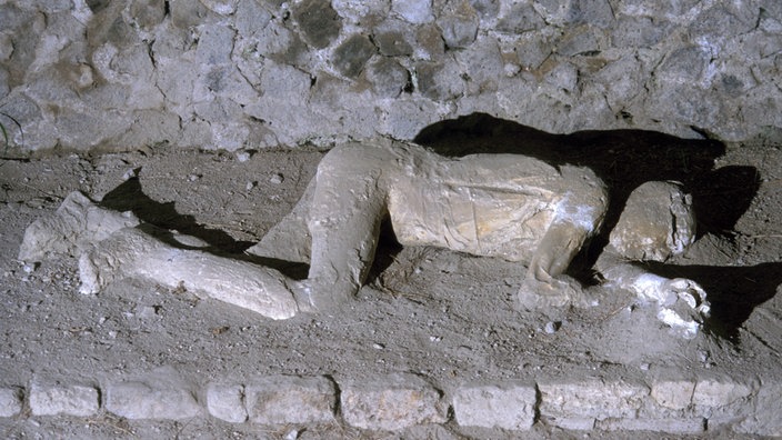 Auf einem Bürgersteig in Pompeji liegt der Gipsabdruck einer Leiche