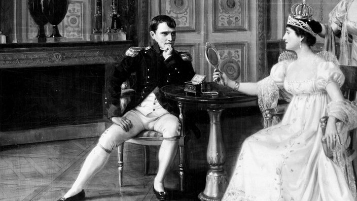 Napoleon Bonaparte und seine Frau Joséphine sitzen in einem eleganten Wohnraum