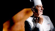 Paul Bocuse mit Kochjacke und -mütze