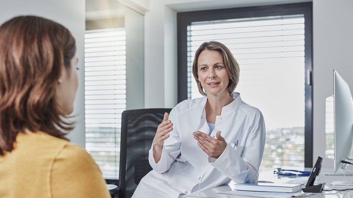 Eine Ärztin spricht mit einer Patientin in einer Arztpraxis