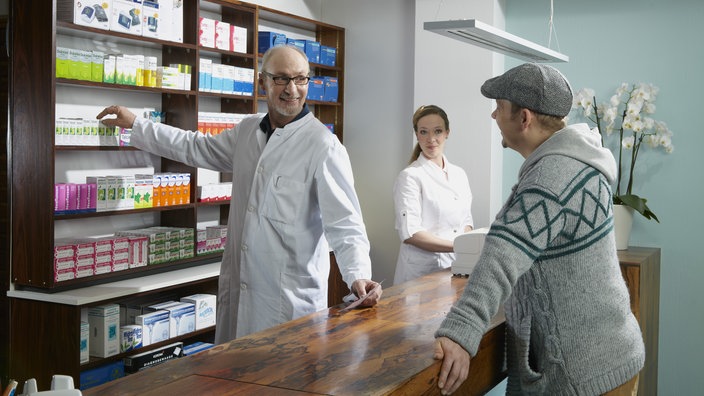 Ein Patient kauft ein Medikament in einer Apotheke.