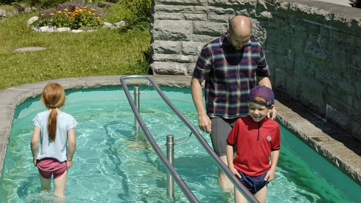 Vater mit Kindern beim Wassertreten.