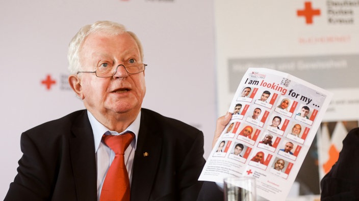 DRK-Präsident Rudolf Seiters präsentiert am 04.05.2015 in Hamburg auf einer Pressekonferenz zur Gründung des DRK-Suchdienstes vor 70 Jahren ein aktuelles Plakat, das für die Online-Suche wirbt