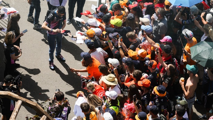 Formel-1-Fahrer Esteban Ocon schreibt Autogramme (2024)