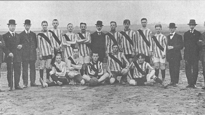 Schwarzweiß-Foto der Dortmunder Mannschaft von 1911 in gestreiften Trikots.