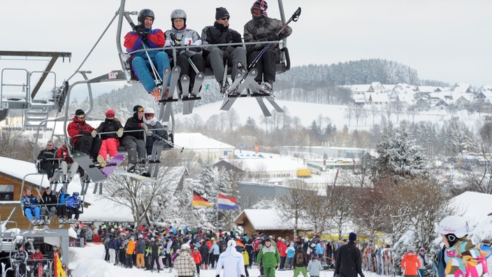 Menschenmassen vor und in Sesselliften