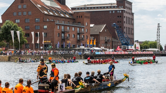 Drachenboot-Regatta im Innenhafen von Duisburg vor der Kulisse der alten Hafengebäude