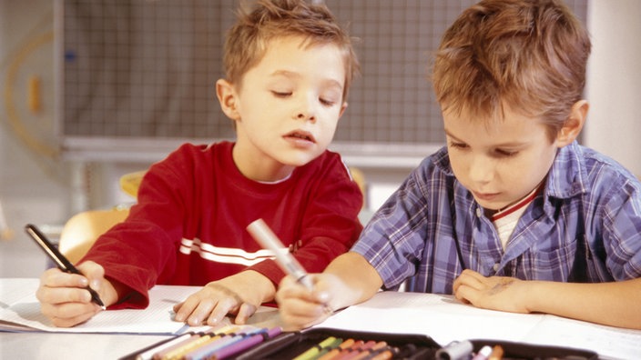 Schüler schreibt bei Schulaufgabe vom Mitschüler ab.