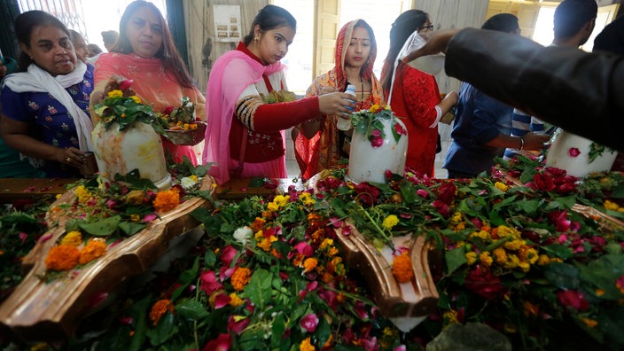 Hindus gießen heiliges Wasser und Milch auf ein Lingam