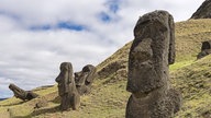 Mehrere große Steinfiguren stehen auf einem Hügel.