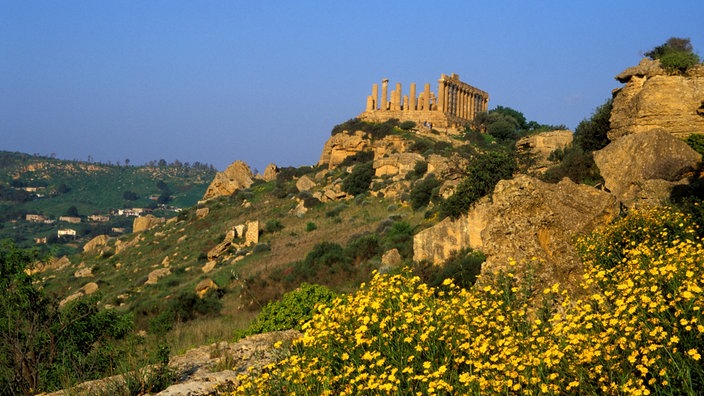 Frontalansicht auf die Ruine eines griechischen Tempels vor strahlend blauem Himmel.