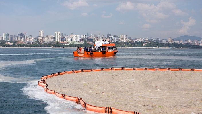 Ein Schiff trägt die obere verschmutzte Schicht des Meerwassers ab.