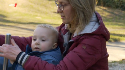 Eine Familie auf dem Sofa: Vater, Mutter, Kind und die Wunschoma