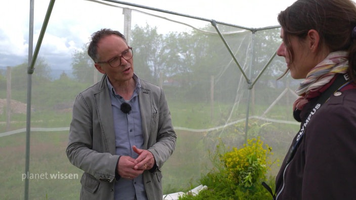 Axel Wagner im Gespräch mit Alexandra-Maria Klein auf einer Wiese.