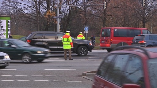 Zwei Polizisten mit Warnwesten im Verkehrschaos.