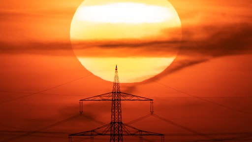 Ein Starkstrommast im Sonnenuntergang 