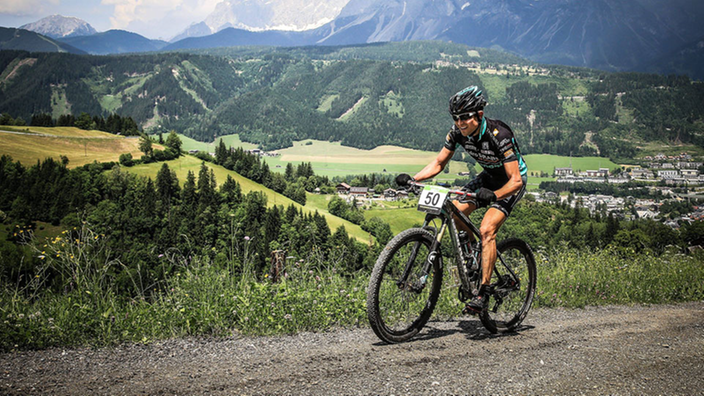 Ein Mann fährt in den Alpen Mountainbike.