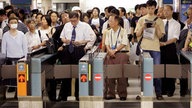 Viele Meschen warten vor den Schranken der Metro-Station von Ikebukuro in Tokio.